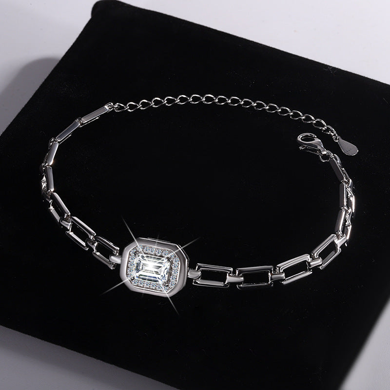 This sophisticated bracelet showcases a radiant-cut crystal centerpiece framed by a glittering halo of smaller stones